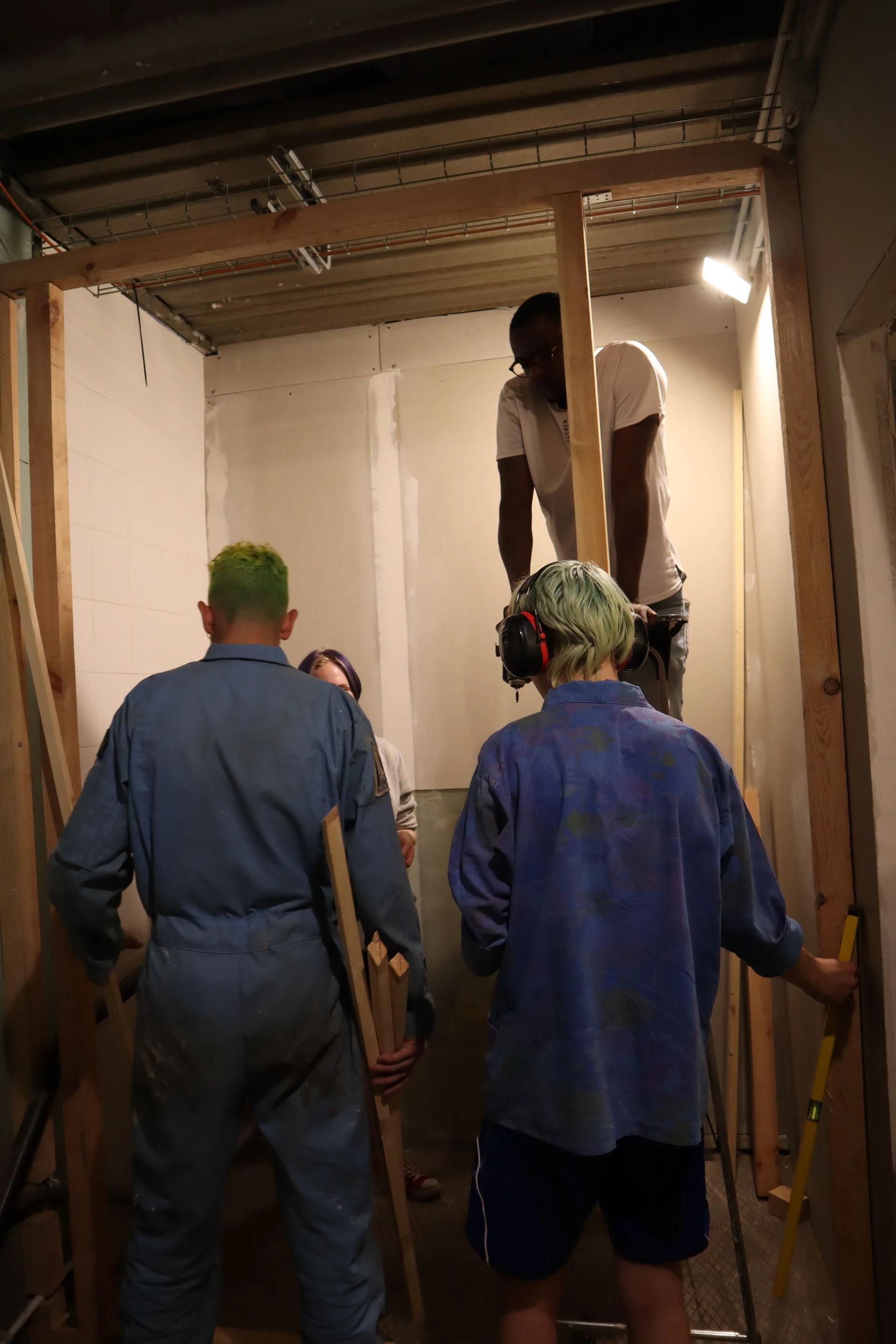 A construction crew positioning timber framing inside a building